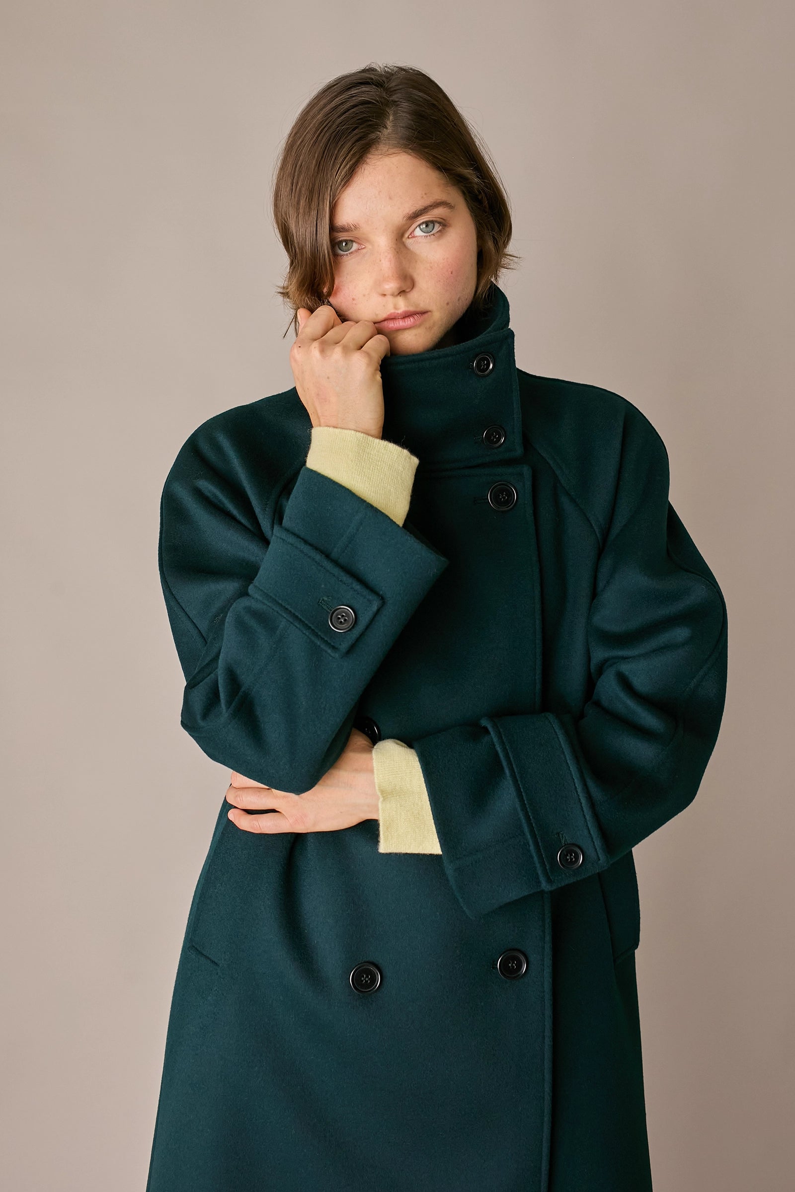 Cappotto con collo alto in lana e cashmere verde scuro, maniche raglan e spacco posteriore