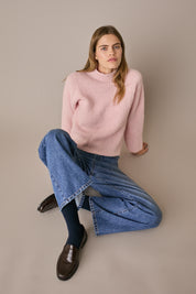 Maglia con collo vulcano rosa, finitura raffinata e linea essenziale