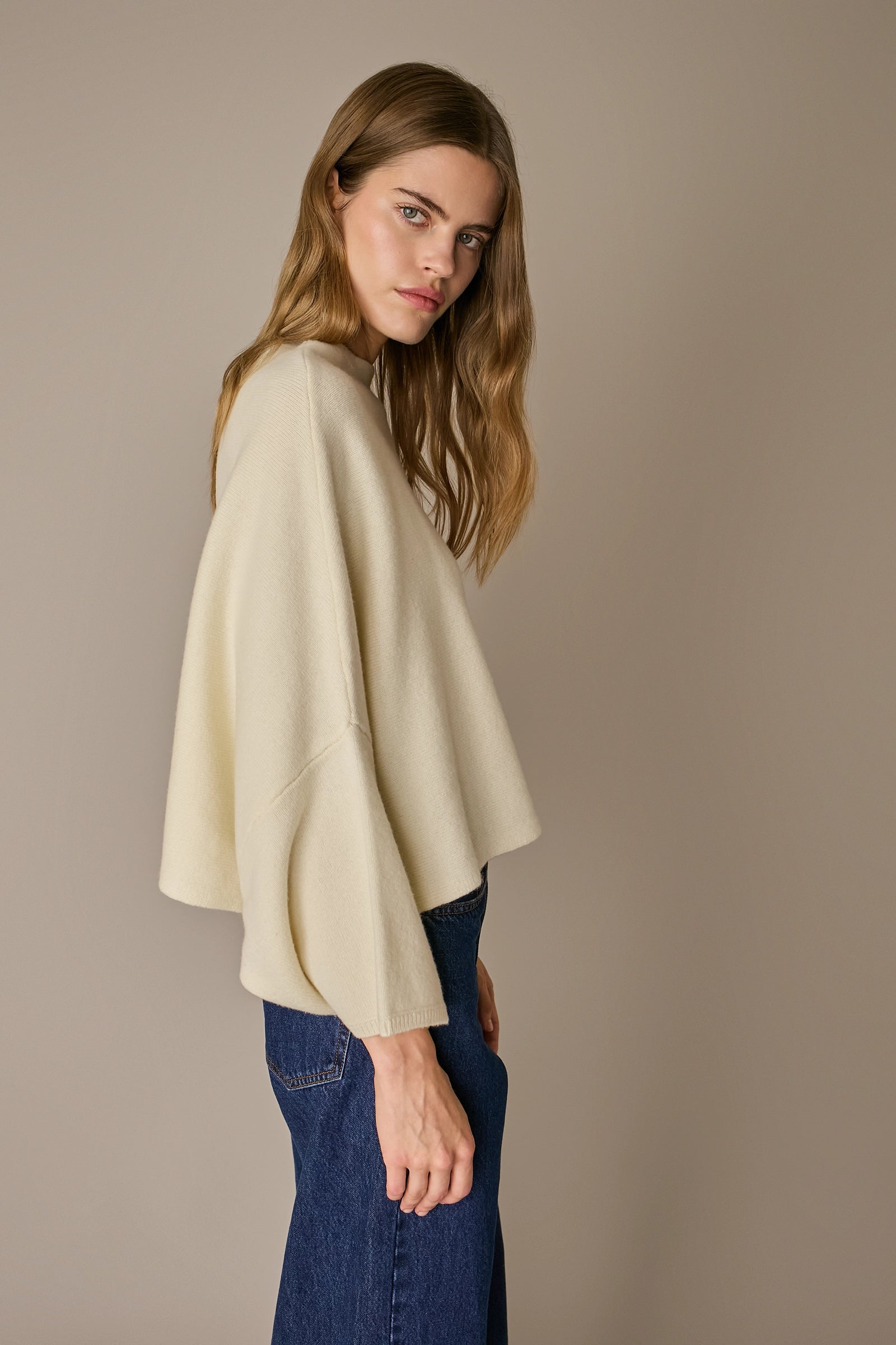 Maglione over a cappa panna, linea essenziale e silhouette versatile
